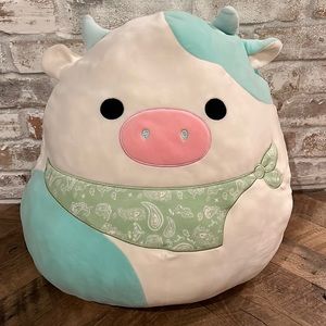 Blue cow squishmallow with green bandanna